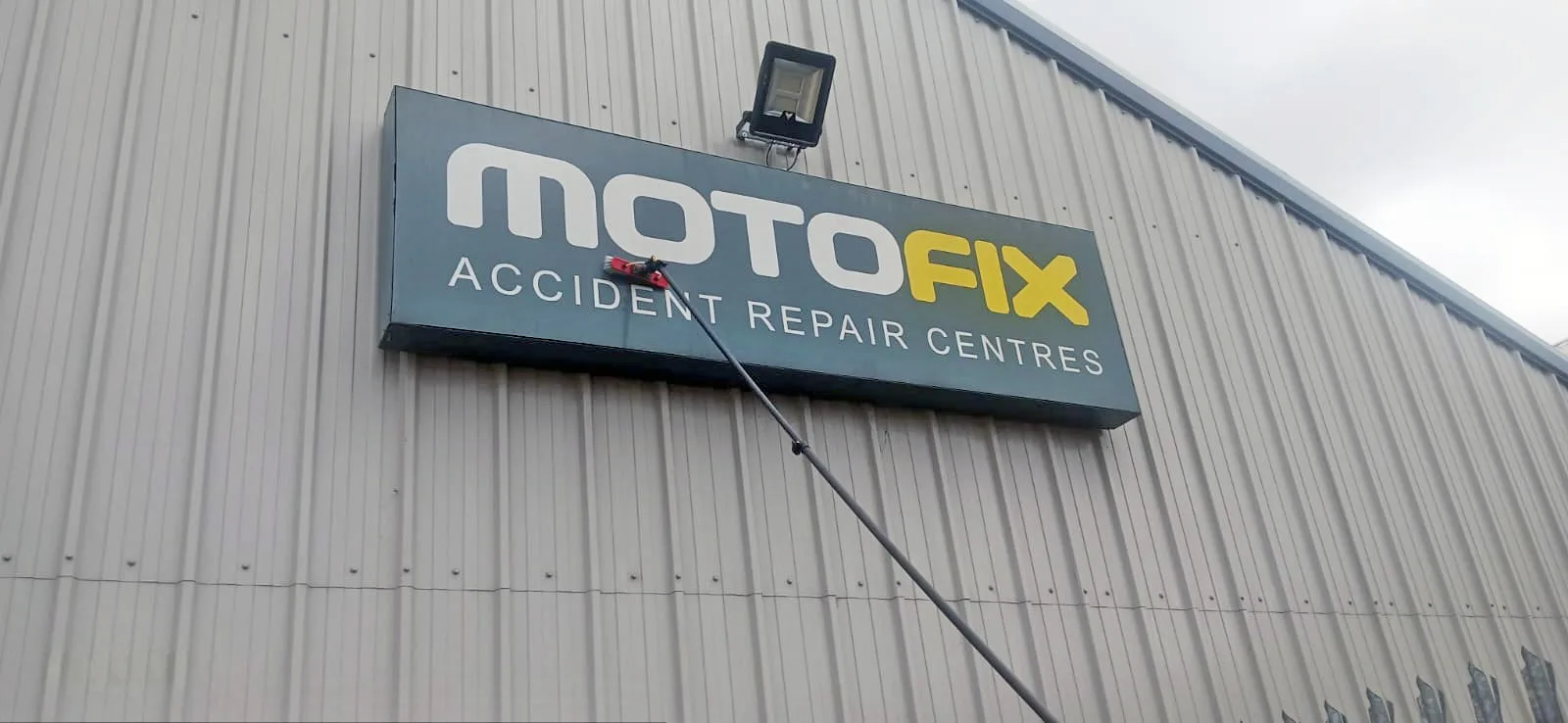 Telescopic pole cleaning commercial cladding panels at height