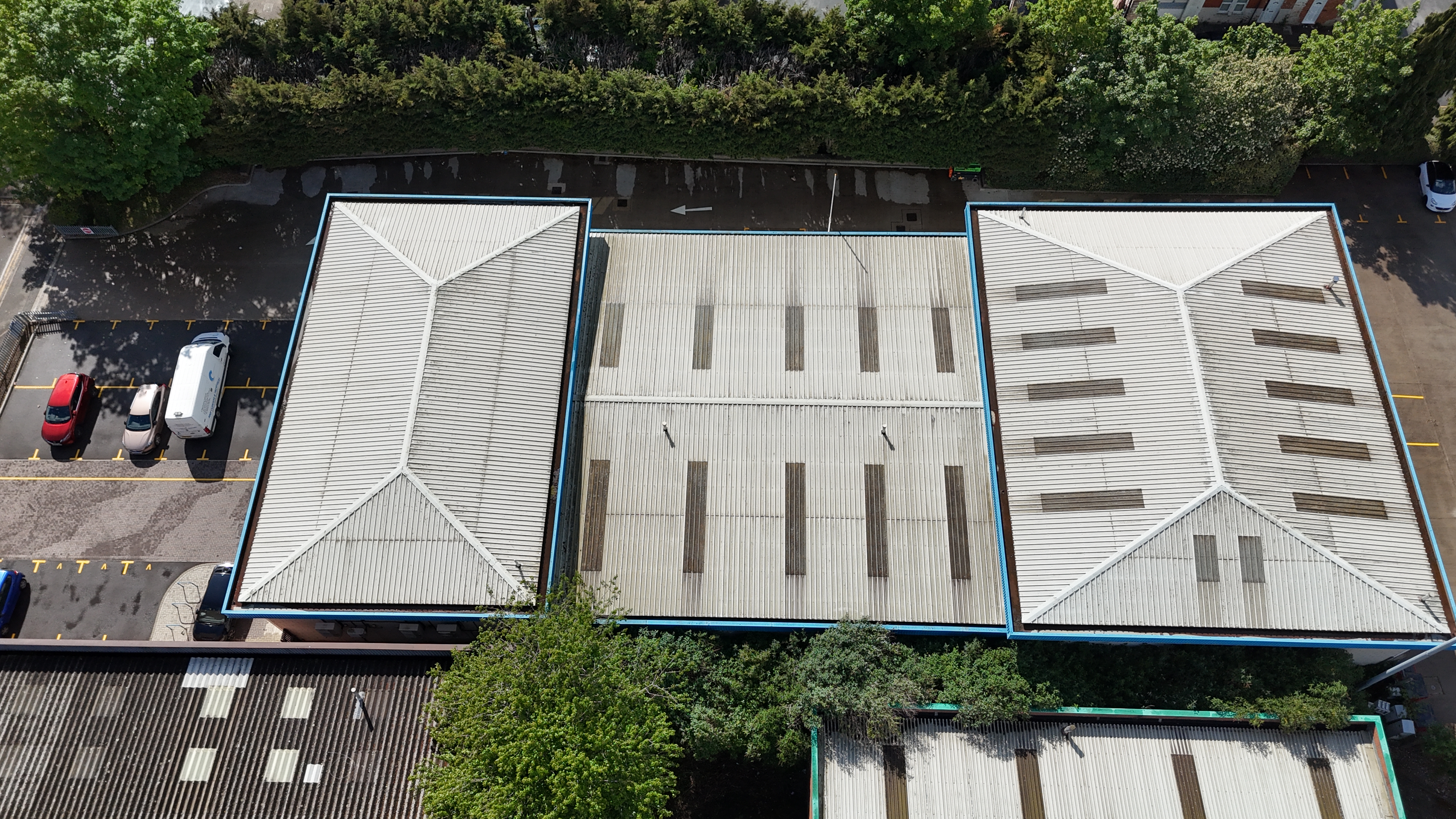 Top-down drone survey of three commercial roof zones over an industrial unit in Northampton, showing tiles, valleys and parking access