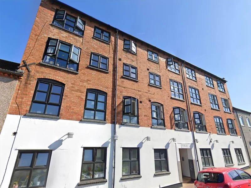 Commercial mixed-use building with clean brick facade and restored render