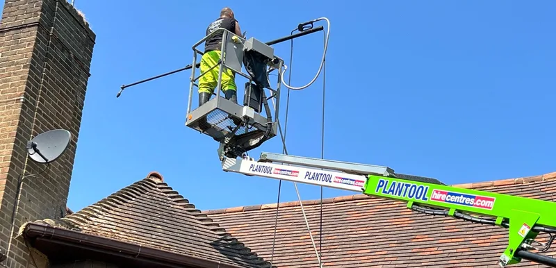 Professional roof moss cleaning from a nifty lift on a high residential roof in Northampton