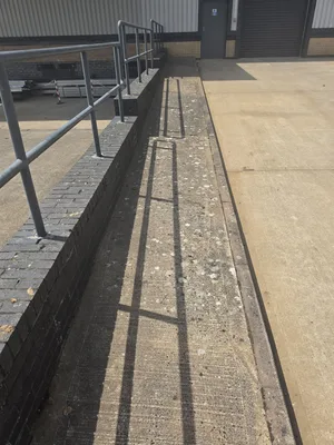 Before - commercial building concrete ledge brick base lichen algae staining, Rugby.