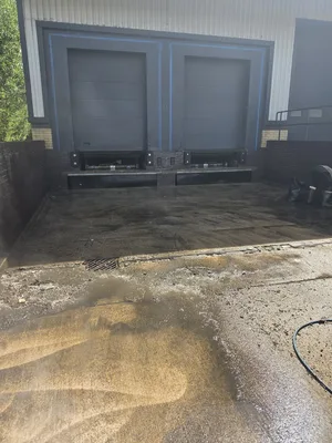 During - commercial concrete service yard algae pressure washed building beside, Rugby.