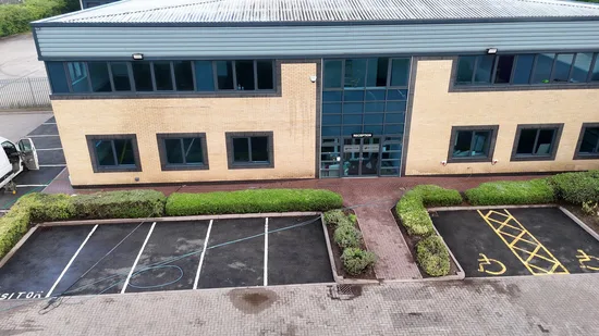 During - commercial building buff brick facade car park pressure washed tarmac, Rugby.