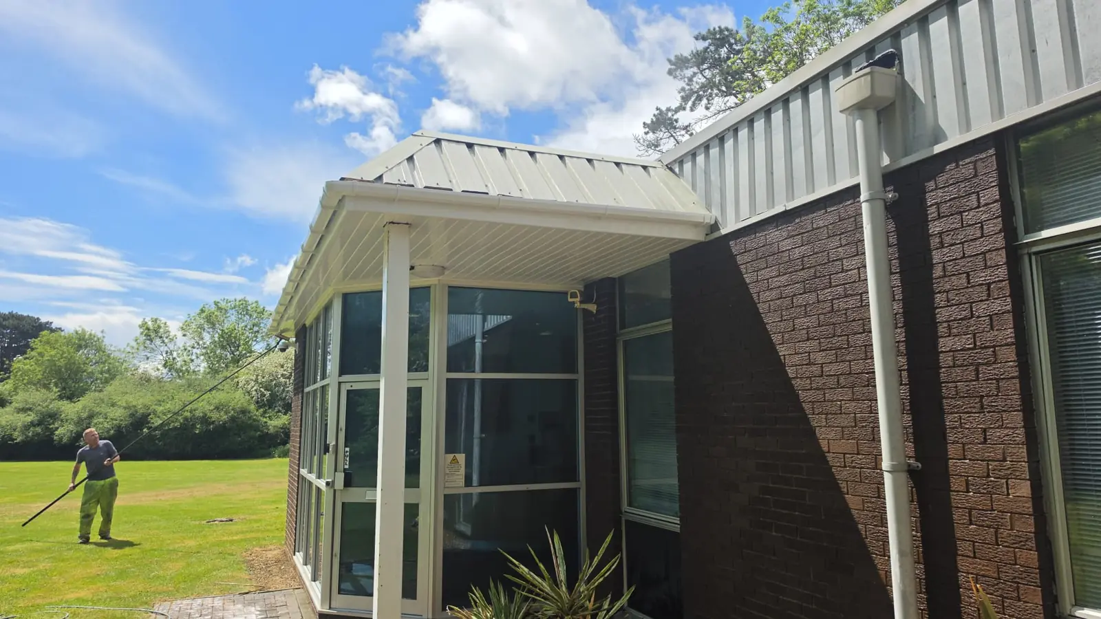 Eurofins BLC entrance canopy cladding after soft wash, Northampton NN3 6JD - clean cream-white finish under blue sky
