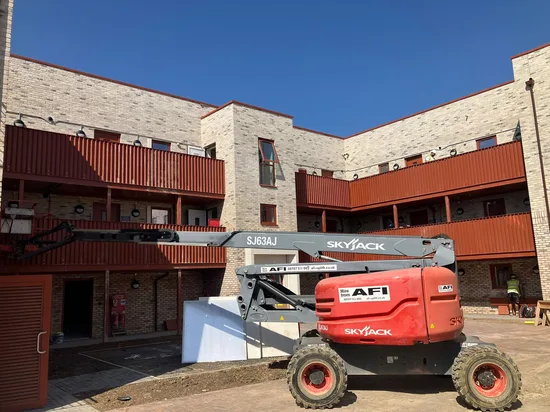 residential development buff brick courtyard boom lift access