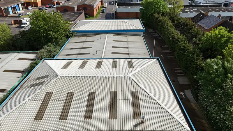 Oblique drone view of the valley between two roof bays of the Globus Medical building with skylights and shadow line
