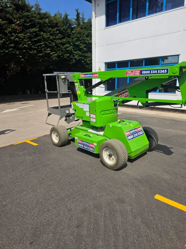Nifty articulated boom MEWP unit HC6747 from hirecentres.com parked in the Globus Medical car park with the green-lime boom and yellow basket