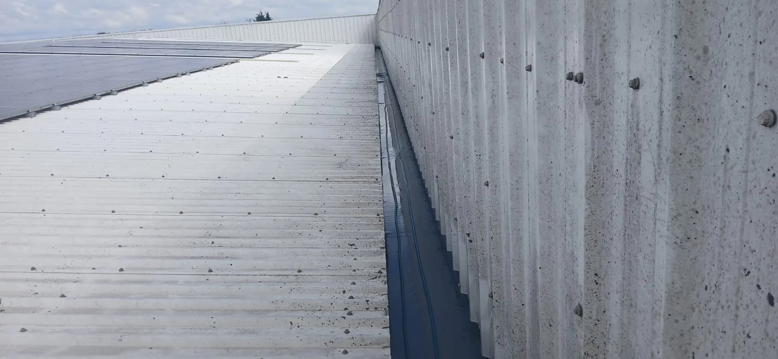 Box gutter between warehouse roof sections after cleaning at Partridges, Desborough