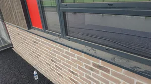 During - commercial school buff brick facade window frames dirty sills, West-Bromwich.
