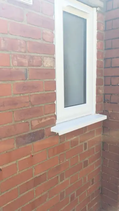 Red brick wall after cleaning, clean around the uPVC window - Luton