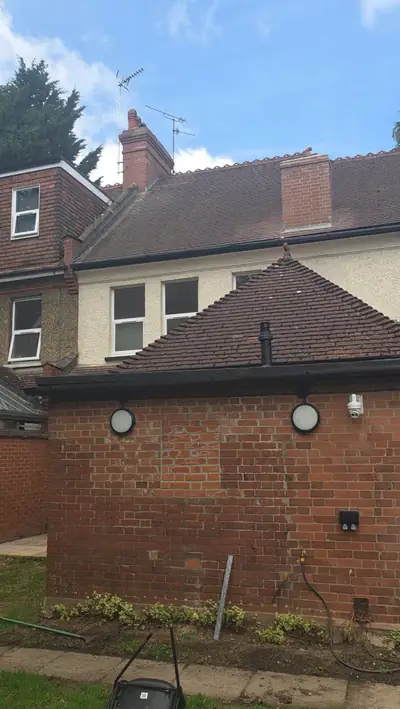 Back of the Luton property before cleaning - clay tile roof with moss and stained brick walls