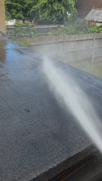 Flat felt extension roof being pressure washed - Luton