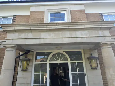 Large period property in Orlingbury before cleaning - buff brick walls and slate roof with algae staining