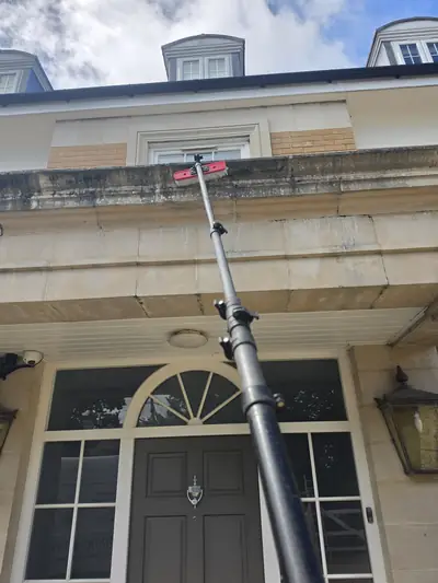 Stone quoins being cleaned with a water-fed pole and soft brush - Orlingbury