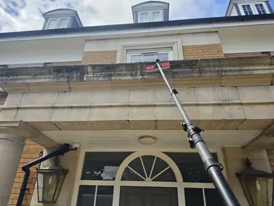 Stone balustrade being cleaned by water-fed pole - Orlingbury