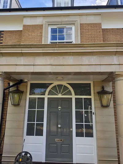 Clean brick and stone entrance with decorative surround and fanlight after cleaning - Orlingbury