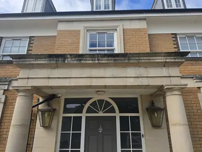 Buff brick facade with algae and soiling before cleaning - Orlingbury period property