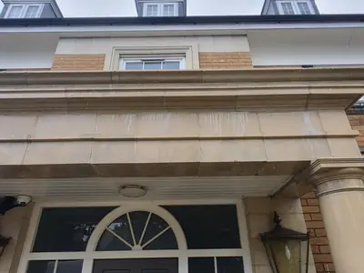 Decorative stone facade with efflorescence and staining before cleaning - Orlingbury