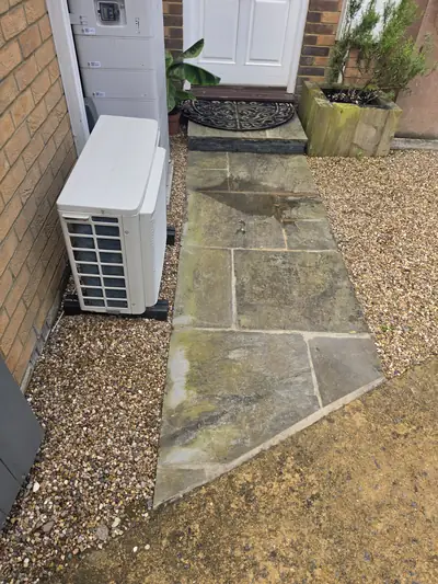 Natural stone flag patio with algae and moss before cleaning - Orlingbury
