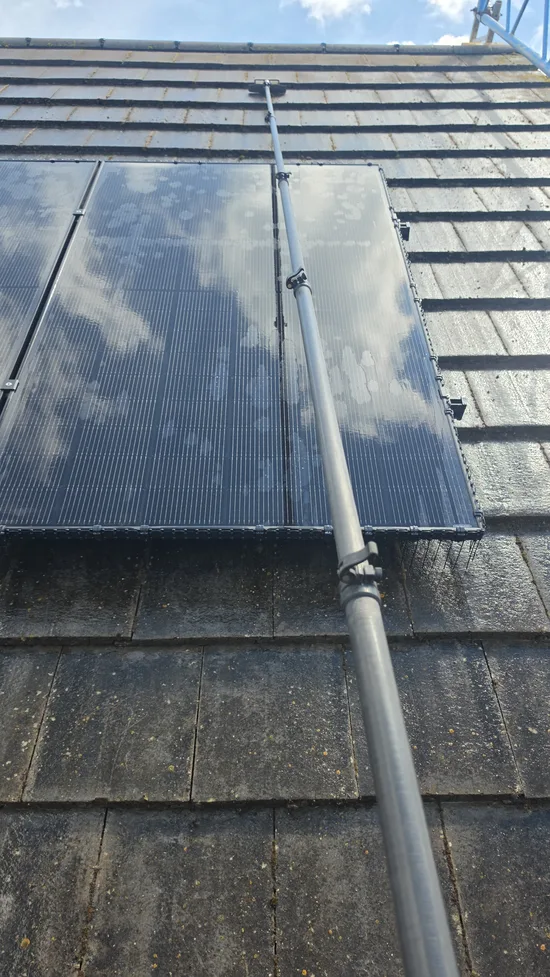 During - residential solar panels water fed pole clean algae soiled roof tiles, Northampton.