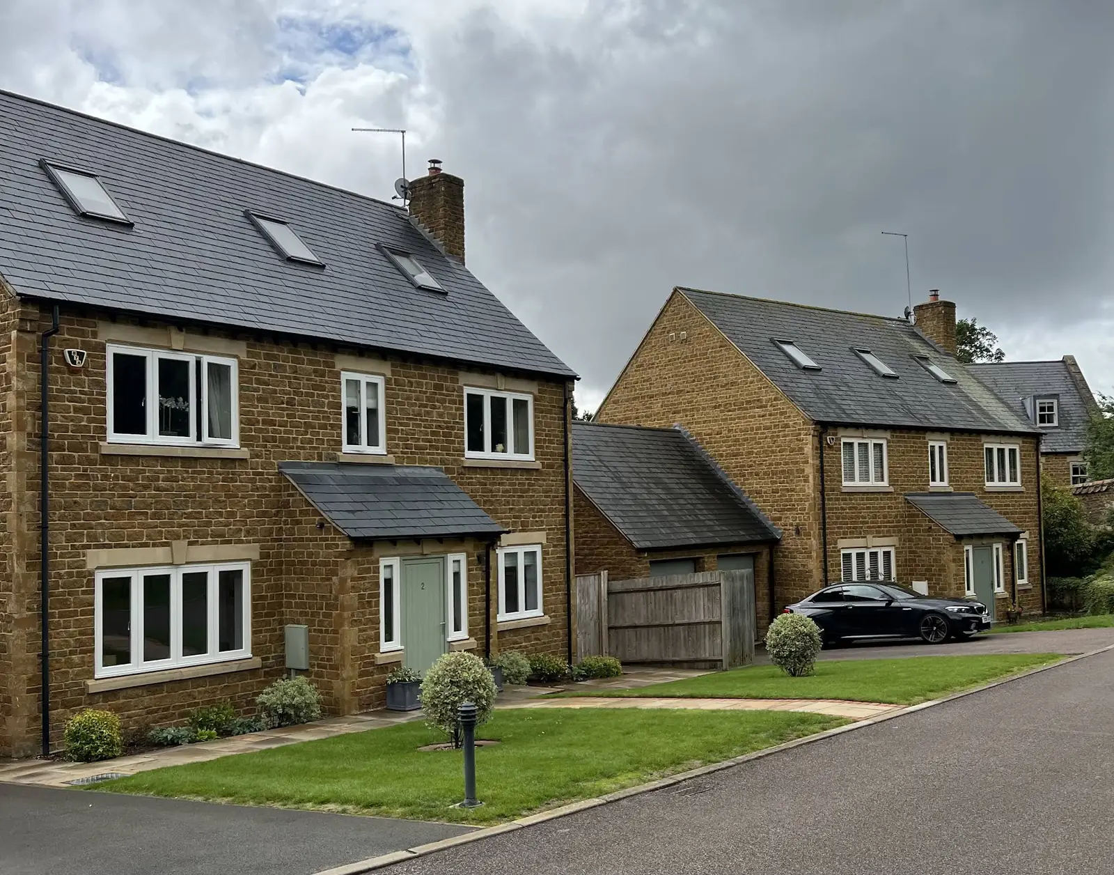 Honey-stone houses with slate roofs still clean eight months after biocide roof treatment