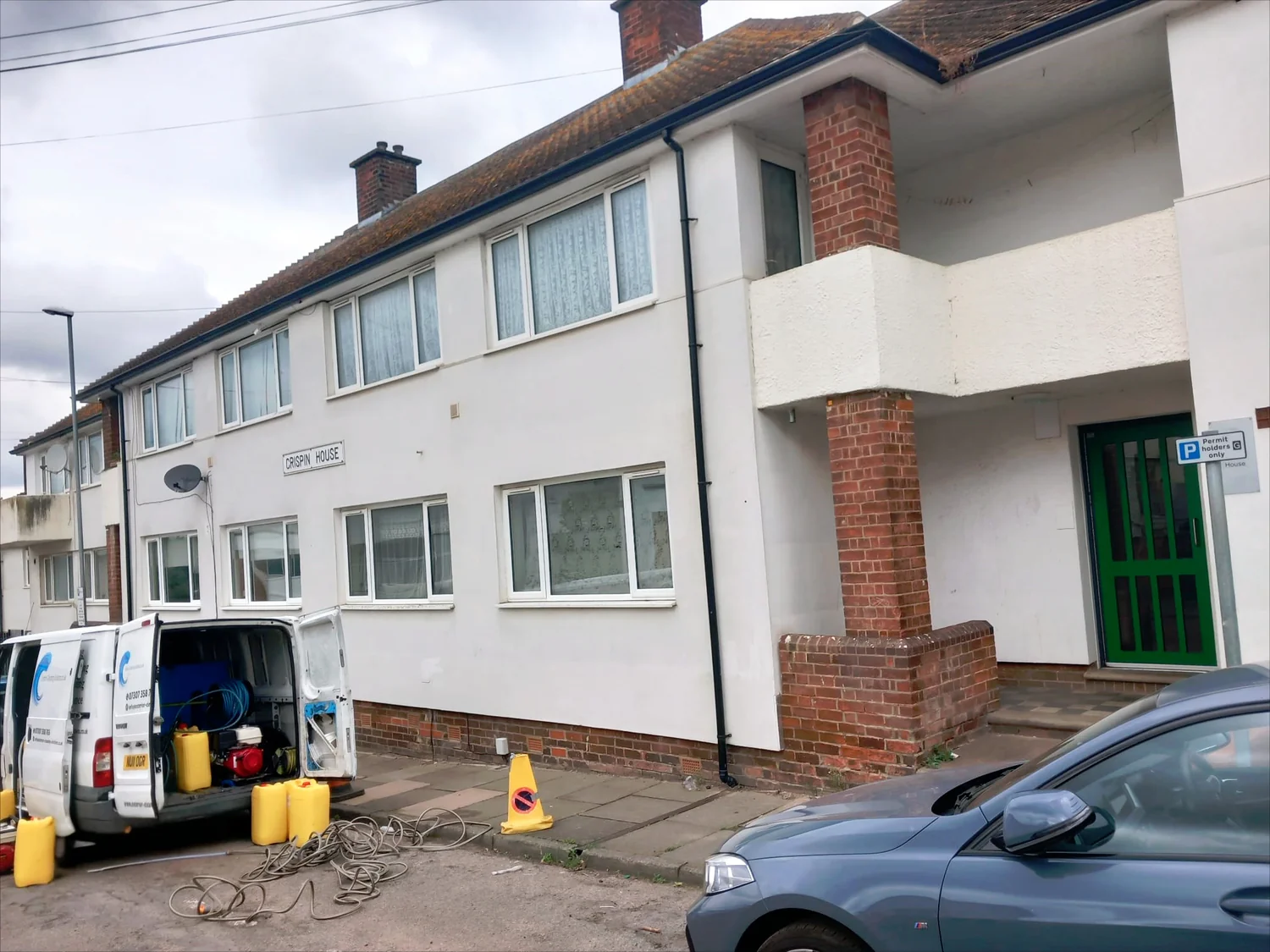 Professional cleaning equipment setup at low rise residential block showing cleaning van and equipment for render cleaning project in Northampton